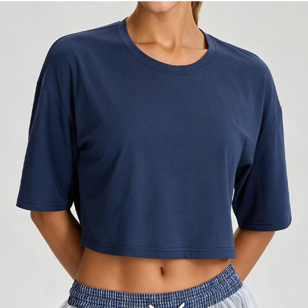 Front view of a women's boxy cropped workout tee in navy blue, featuring a relaxed oversized fit and crew neckline.