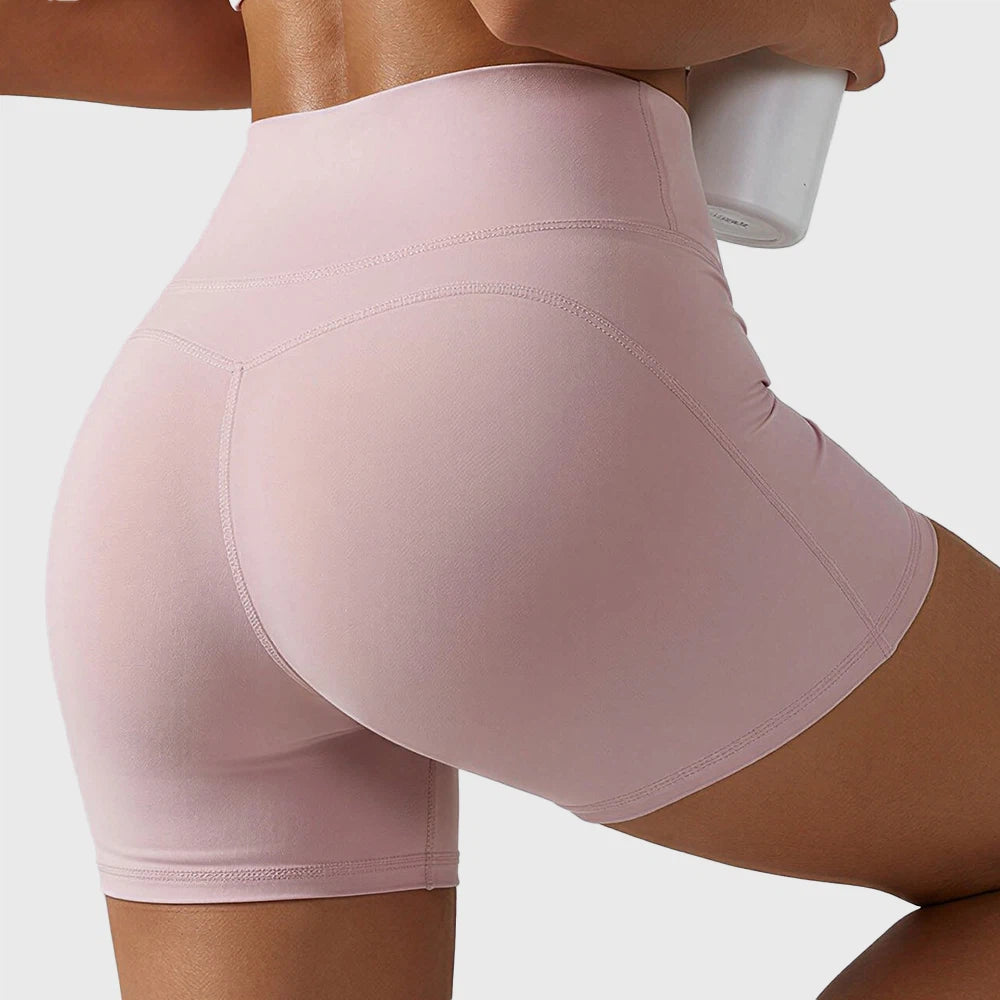 Glute contour seam and booty lifting fit on soft pink running shorts with custom logo, supplied by sportswear manufacturer.