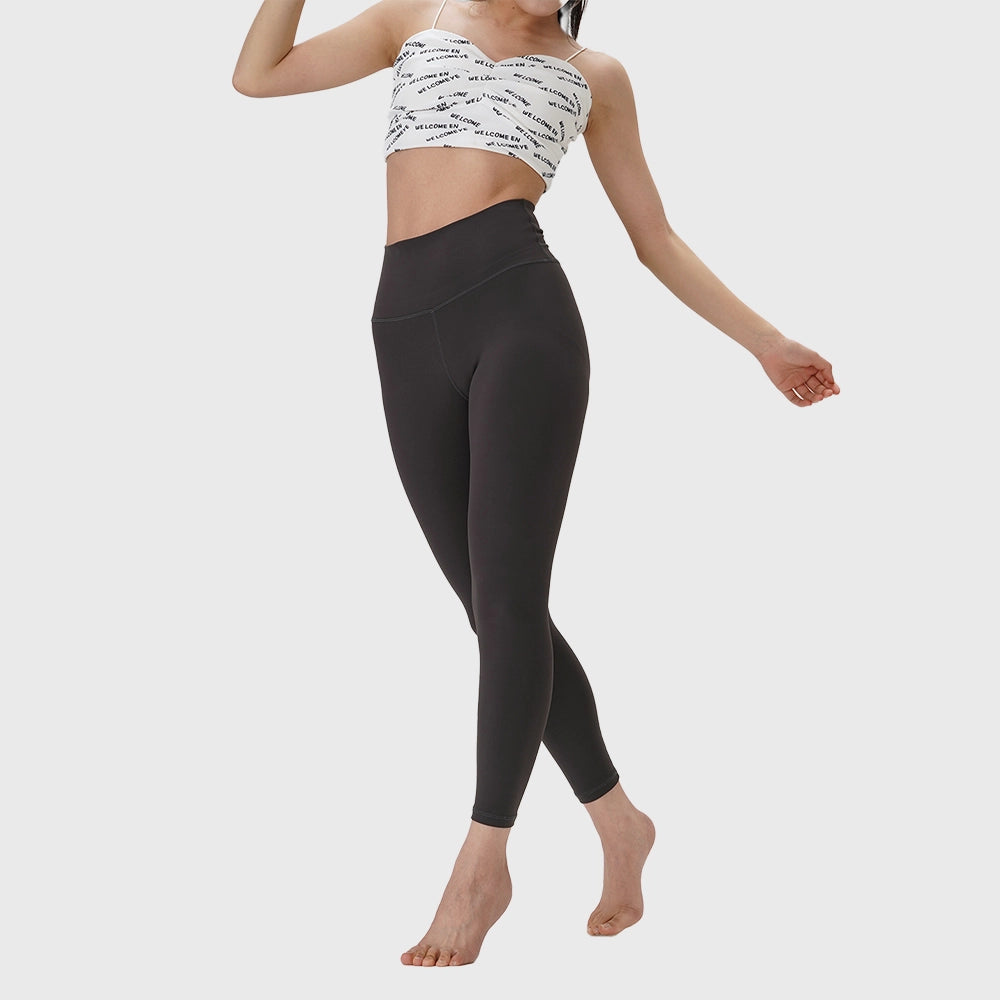 Full body view of women's naked feel athletic workout leggings in charcoal grey with custom logo, custom yoga apparel manufacturer.
