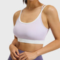Front view of women's lilac purple colorblock sports bra with contrast white trim and custom logo, produced by activewear manufacturer.