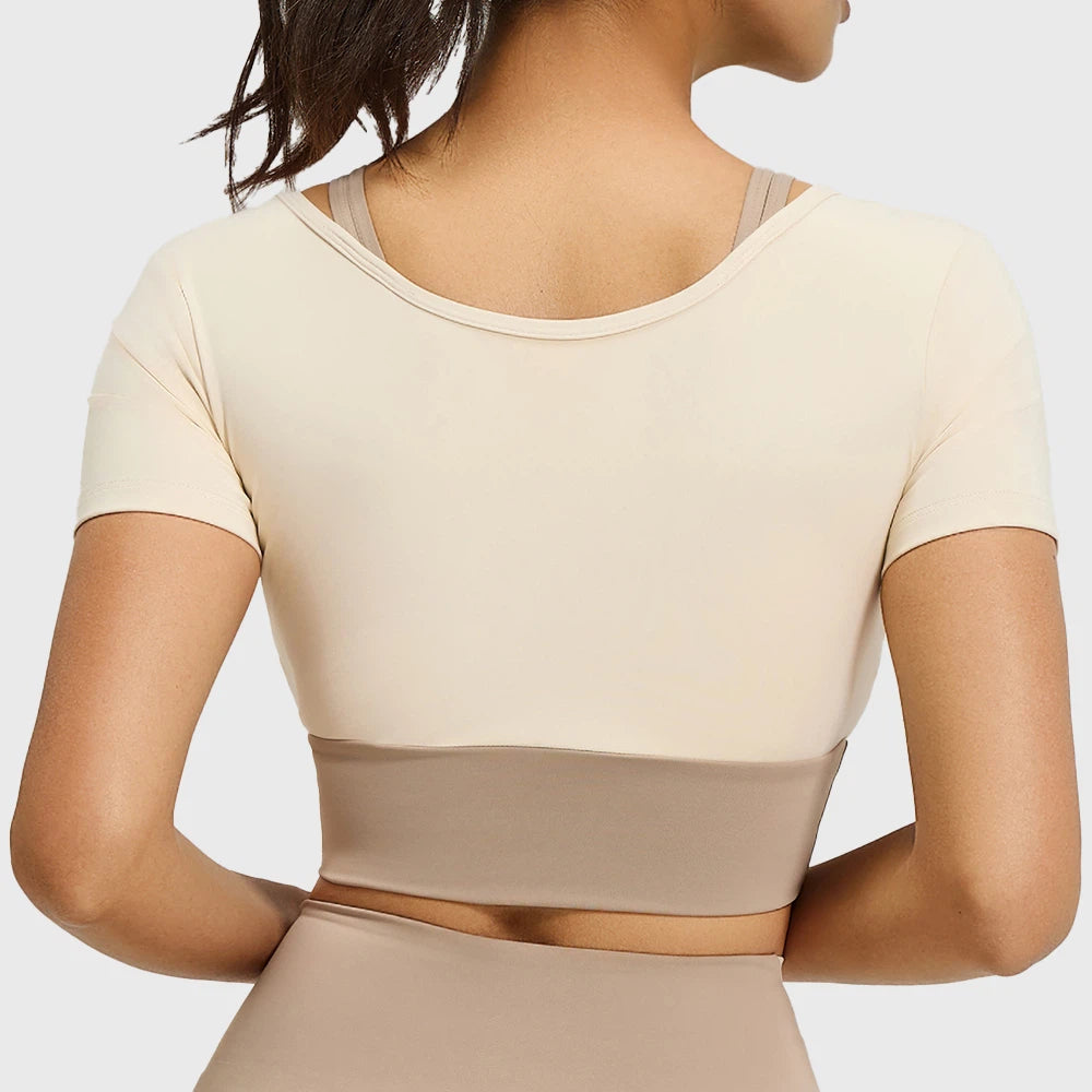 Back view of women's colorblock layered short sleeve workout top in tan and cream with custom logo, OEM gym wear manufacturer.