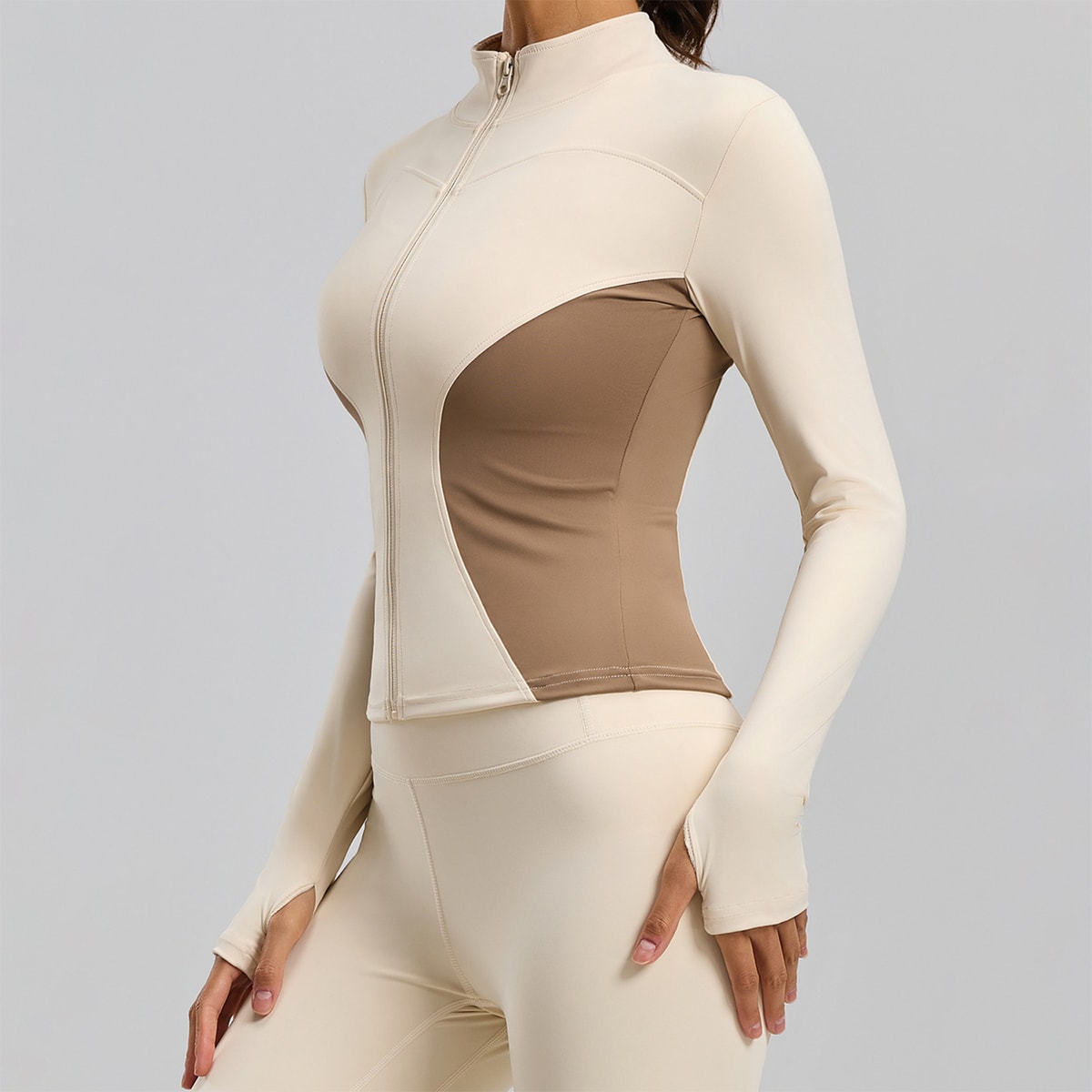 Side view of a beige and tan colorblock slimming full-zip workout jacket.