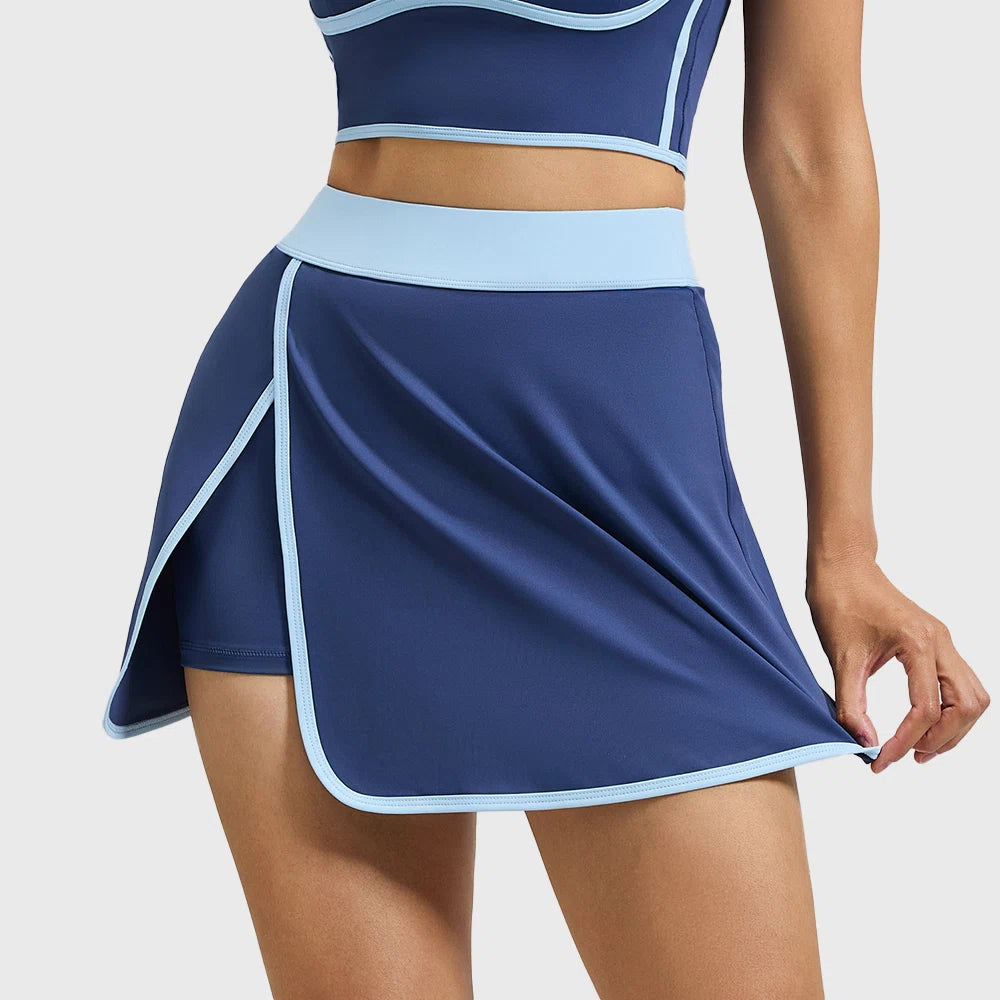 Front view of women's curved hem athletic yoga skort with contrast trim in navy blue with custom logo, custom sportswear manufacturer.
