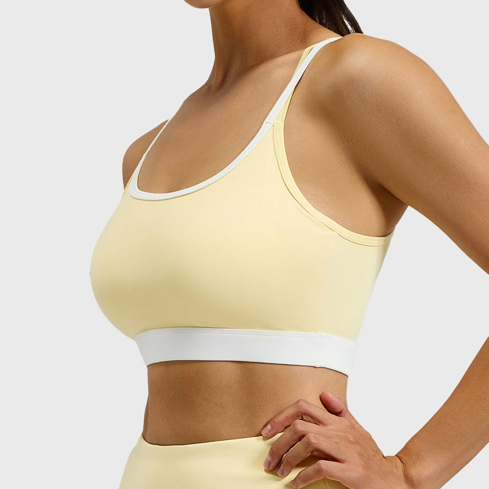 Side profile and fit of butter yellow contrast piping sports bra with custom logo placement, crafted by professional clothing manufacturer.