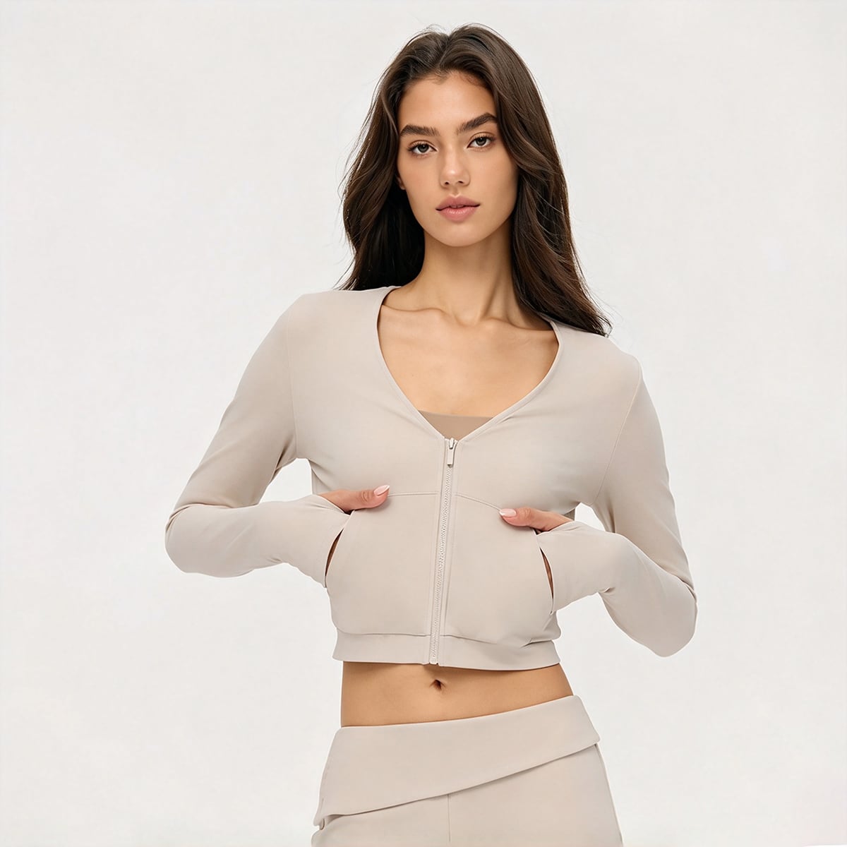 Model placing hands in pockets of a cream V-neck full-zip athletic jacket.