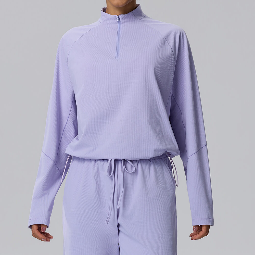 Lavender-colored cropped half-zip athletic top for women, made from lightweight, breathable textured material.