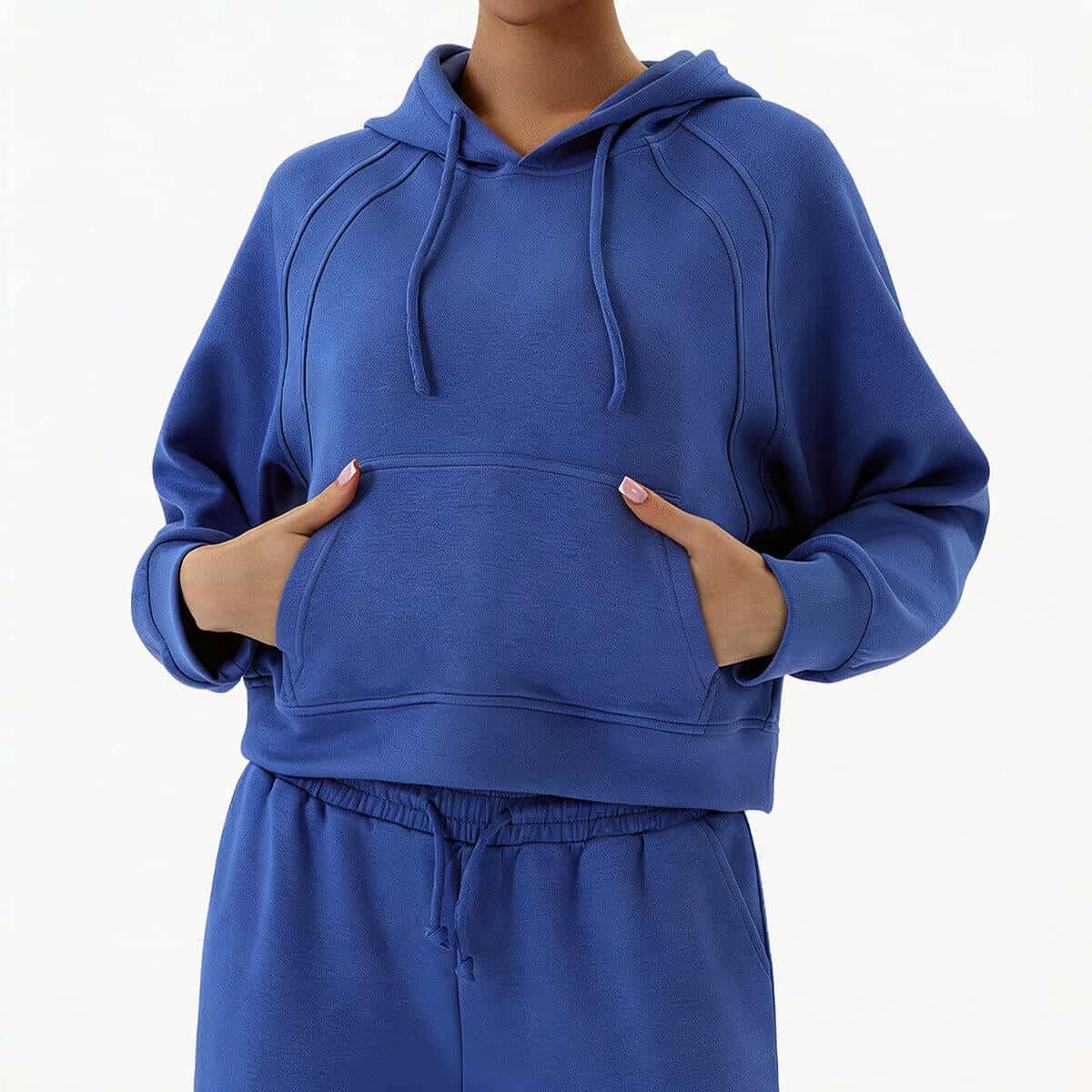 Front view of a woman wearing a vibrant royal blue two-piece lounge set with a cropped drawstring hoodie and high-waisted sweatpants.