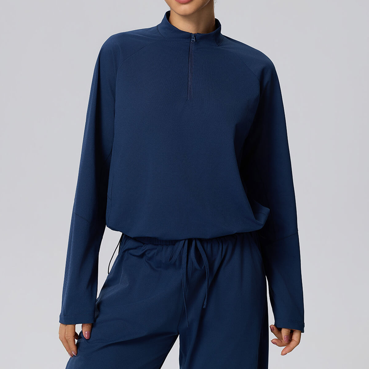 Navy blue cropped quarter-zip sweatshirt for women, featuring moisture-wicking fabric and an adjustable cinch hem