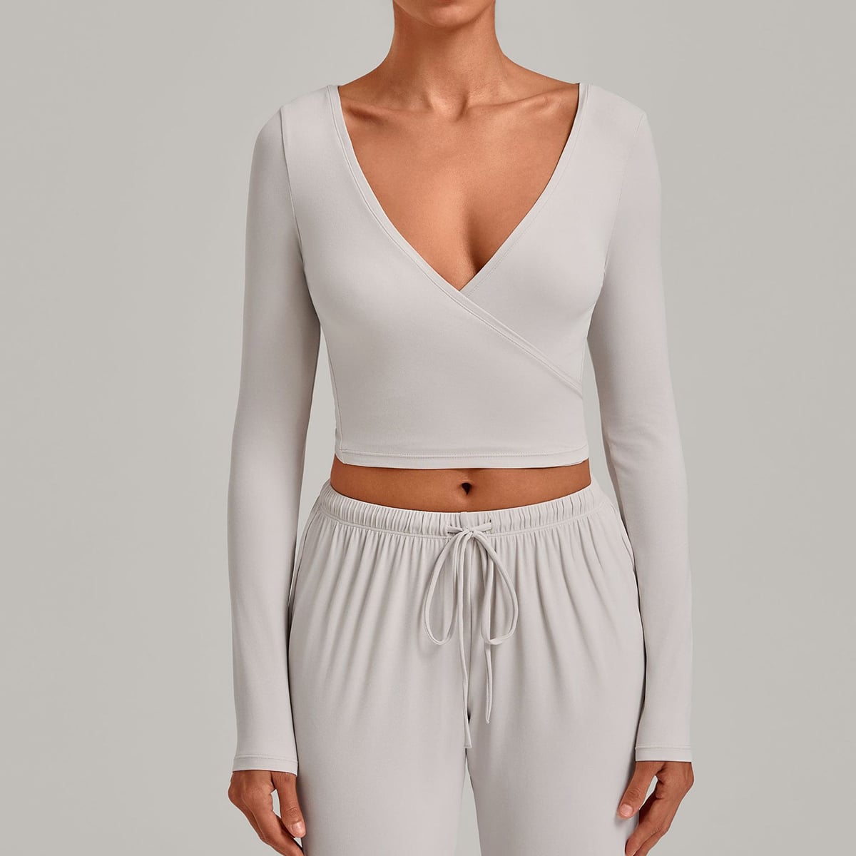 Front view of a light grey long-sleeve crossover athletic wrap top.