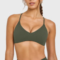 Front look of dark olive green curved hem yoga sports bra with custom logo, supplied by athletic apparel manufacturer.