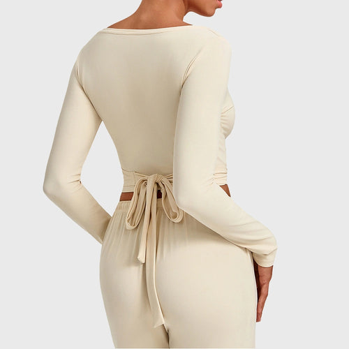 Fit view of women's long sleeve crossover wrap crop top in cream with custom logo, yoga apparel manufacturer.