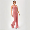  Model walking in a dusty rose pink halter flare-leg athletic onesie.