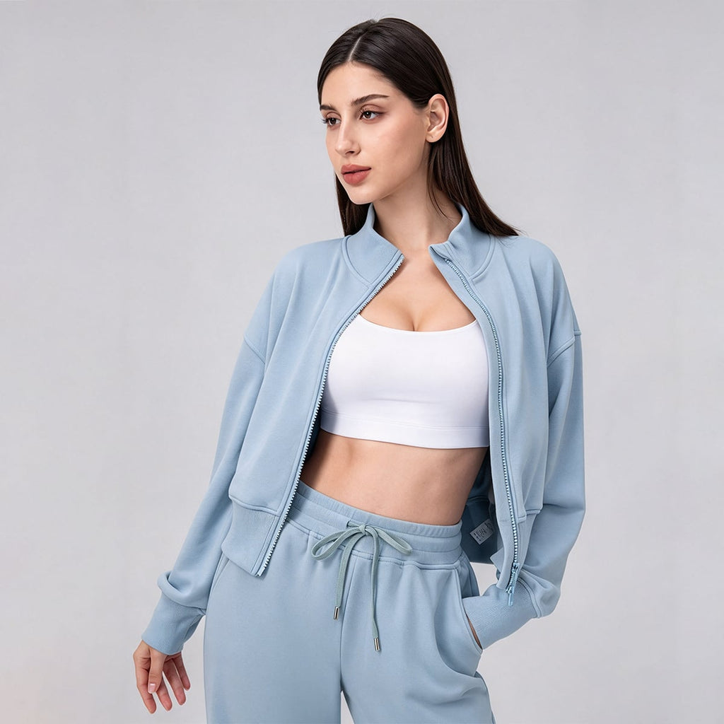 Sky blue cropped scuba jacket open over a white sports bra.