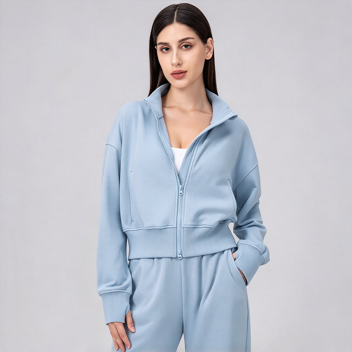 Model wearing a sky blue cropped funnel-neck full-zip athletic jacket.