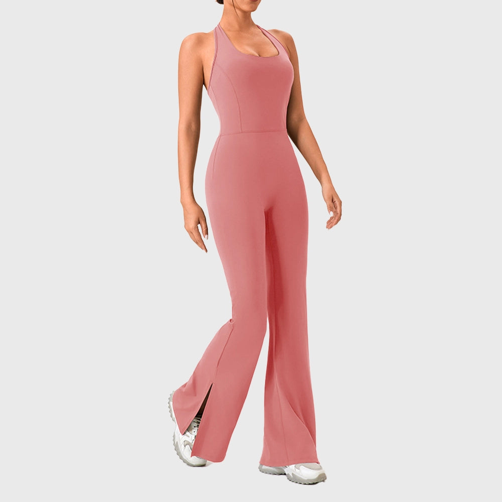 Full body stride view of women's halter flared yoga jumpsuit in dusty pink with custom logo, sportswear manufacturer.
