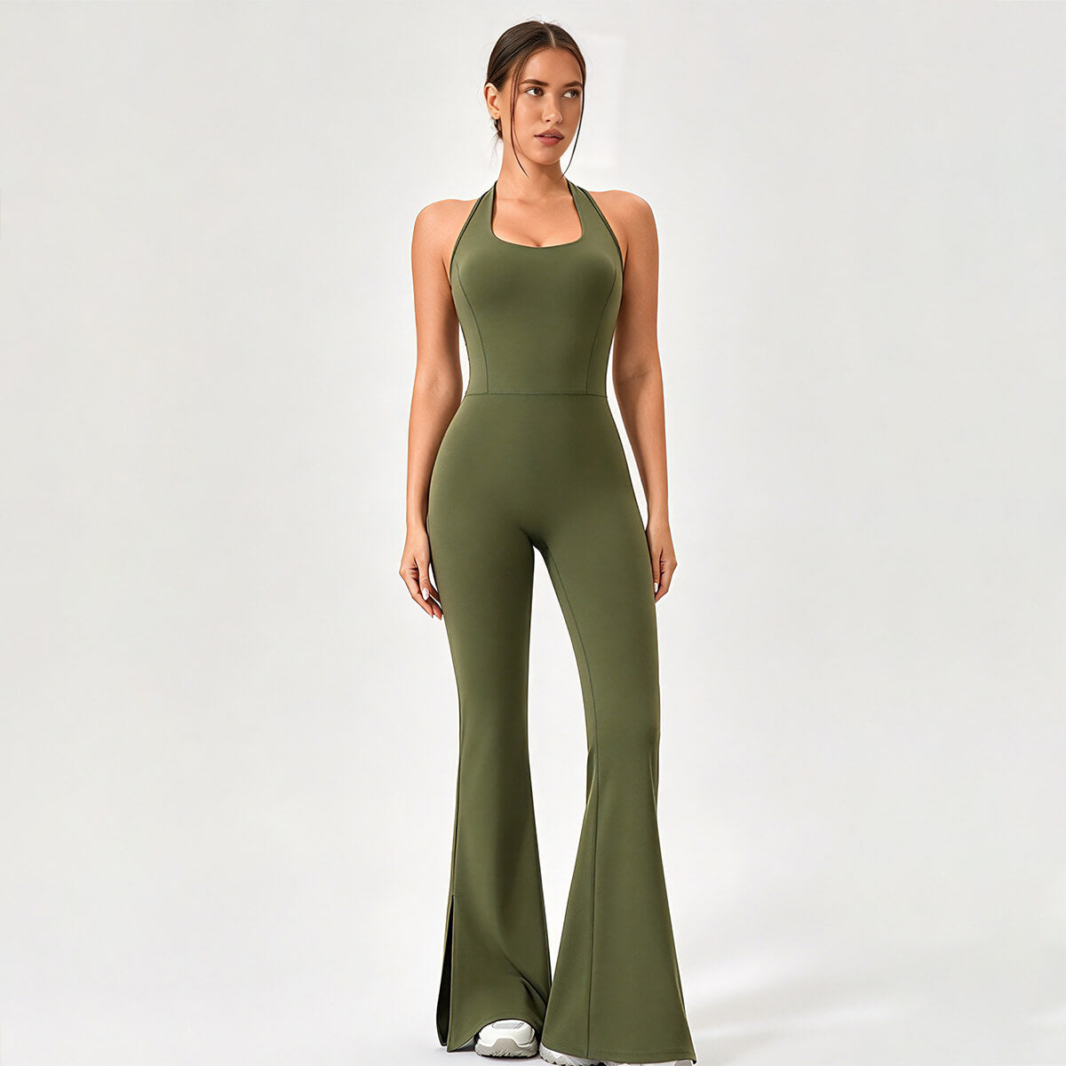 Front view of an olive green halter-neck flare leg yoga jumpsuit with slit hems.