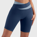 Women's crossover two-tone waist athletic workout shorts in navy blue with custom logo, custom yoga apparel manufacturer - front view.
