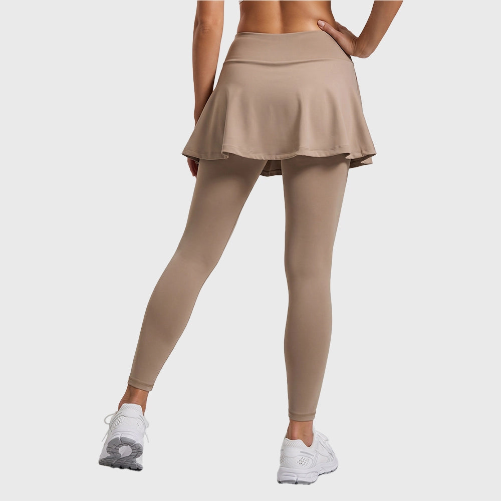Back view of women's high waisted flared skirted leggings in tan with custom logo, athletic apparel manufacturer.

