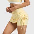 Side profile showing adjustable drawstring tie on women's pastel yellow tennis skort with custom logo, fitness clothing manufacturer.