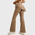 Side back view of women's high waisted flare yoga pants with skirt overlay in khaki with custom logo, sportswear manufacturer.
