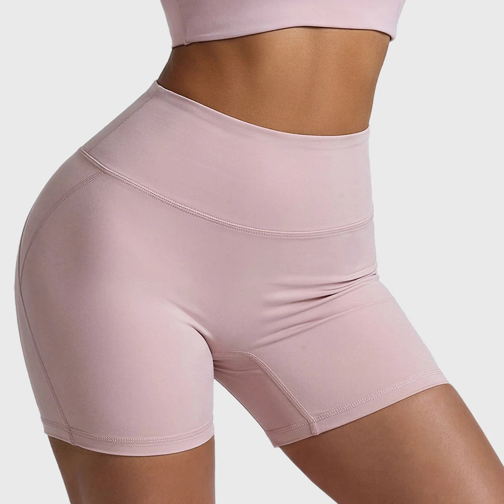 Front and side profile of soft pink high waisted biker shorts with custom logo, made by fitness apparel manufacturer.
