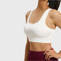 Women's keyhole racerback athletic sports bra in white with custom logo, direct sportswear manufacturer.
