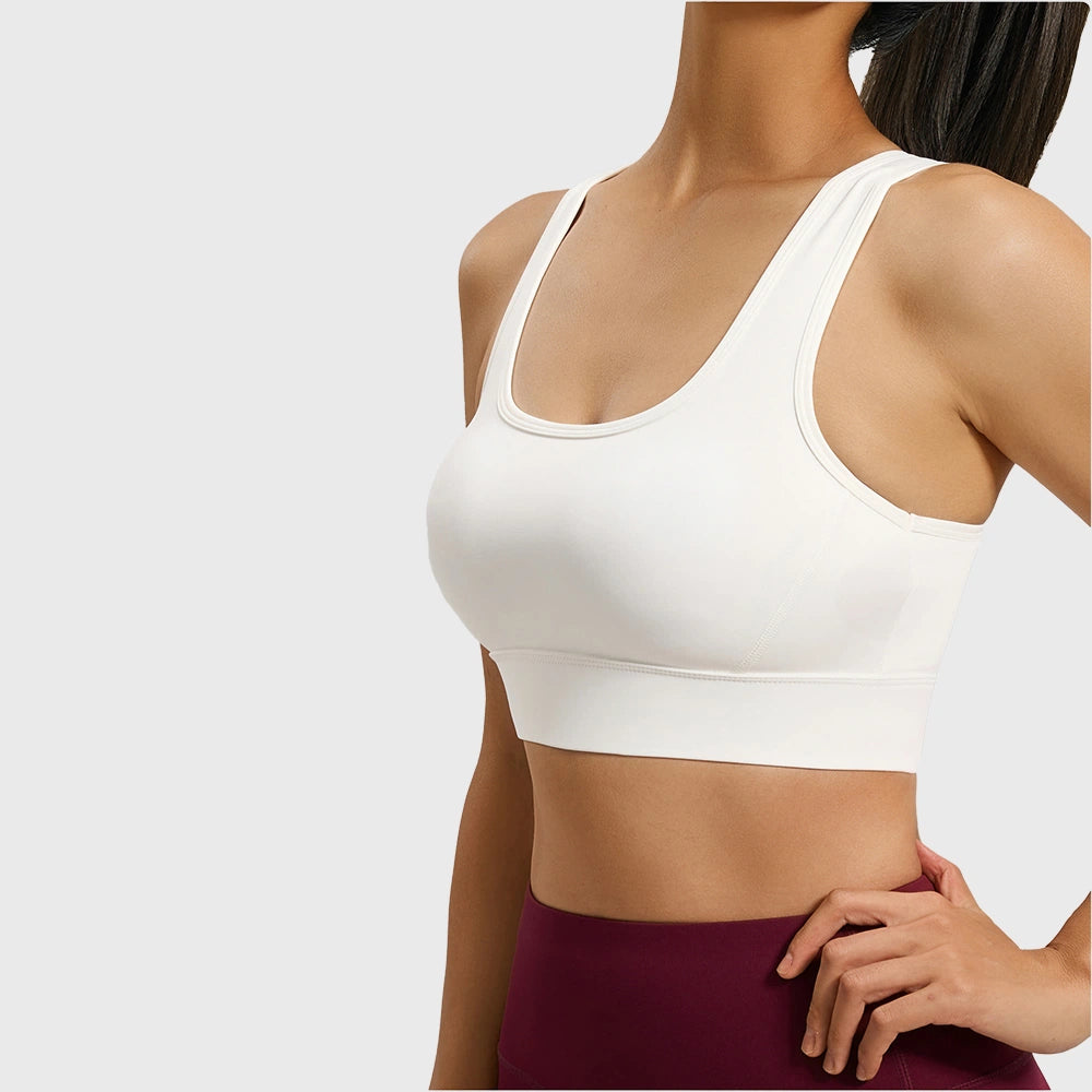 Women's keyhole racerback athletic sports bra in white with custom logo, direct sportswear manufacturer.
