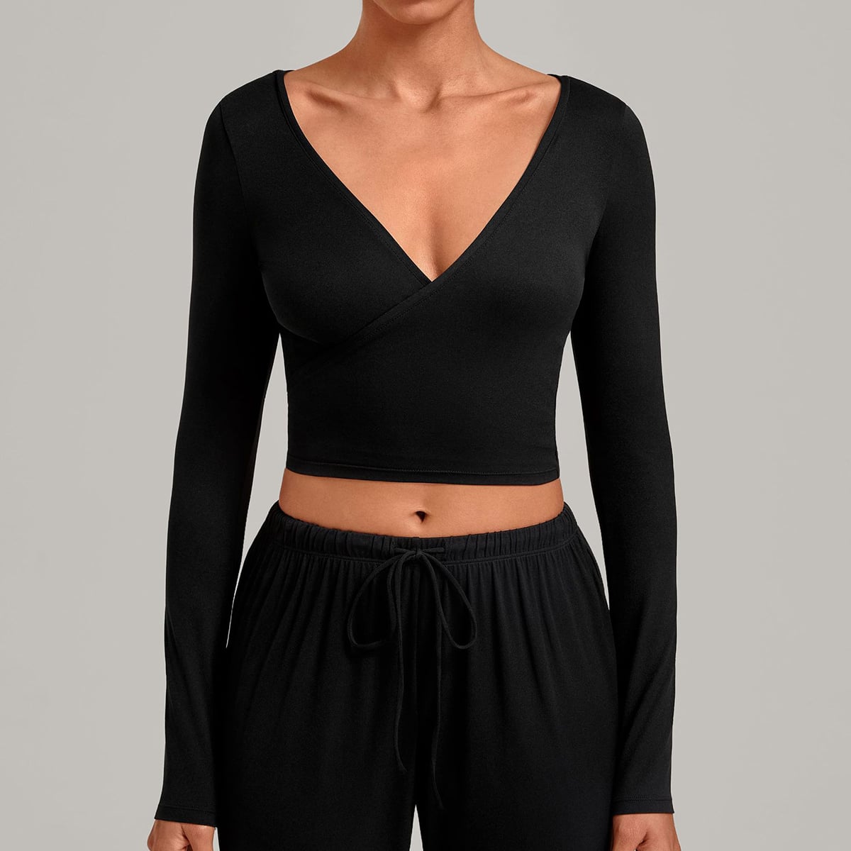 Front view of a black long-sleeve V-neck ballet wrap crop top.