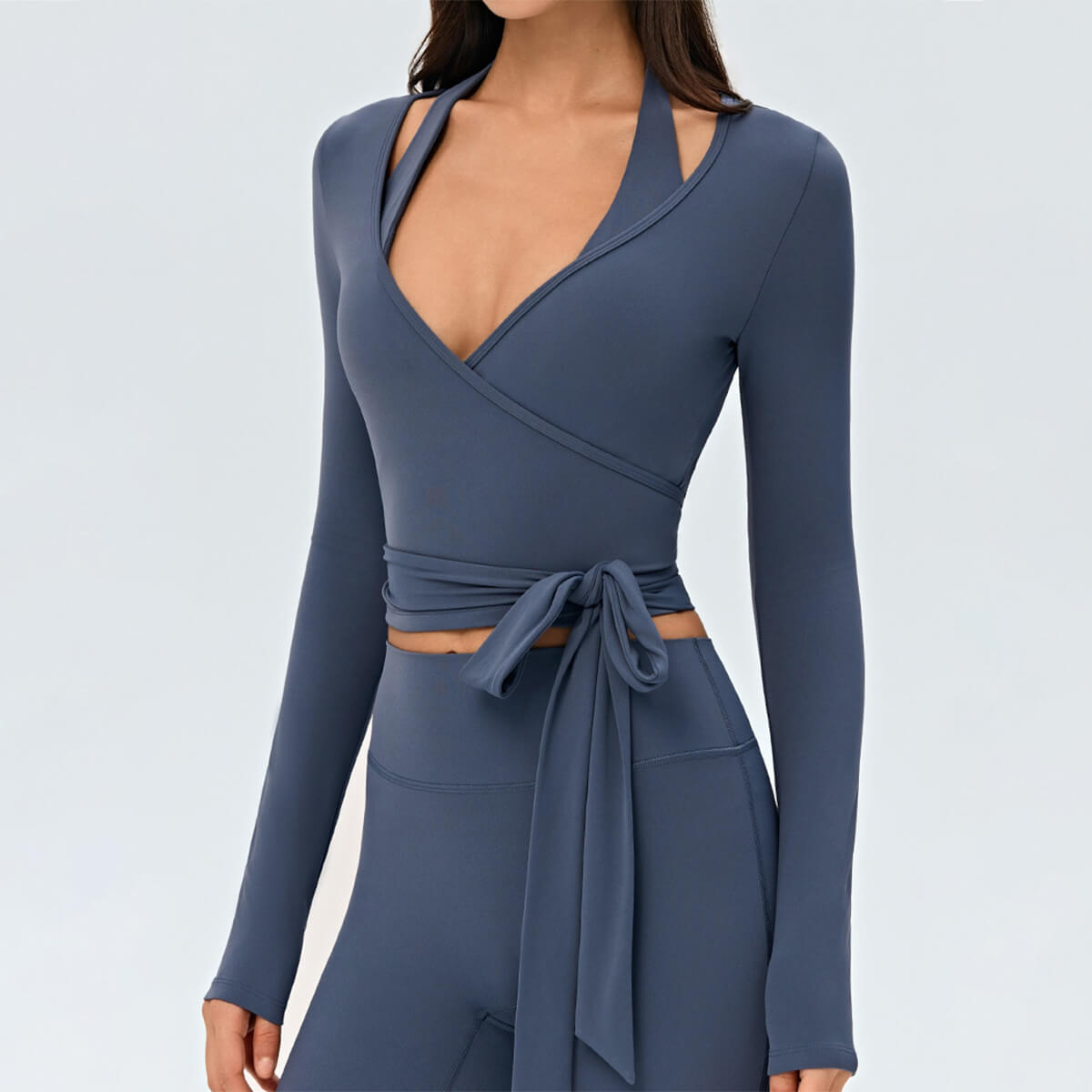 Detailed front view of a slate blue long-sleeve ballet wrap top with a stylish side-tie bow.