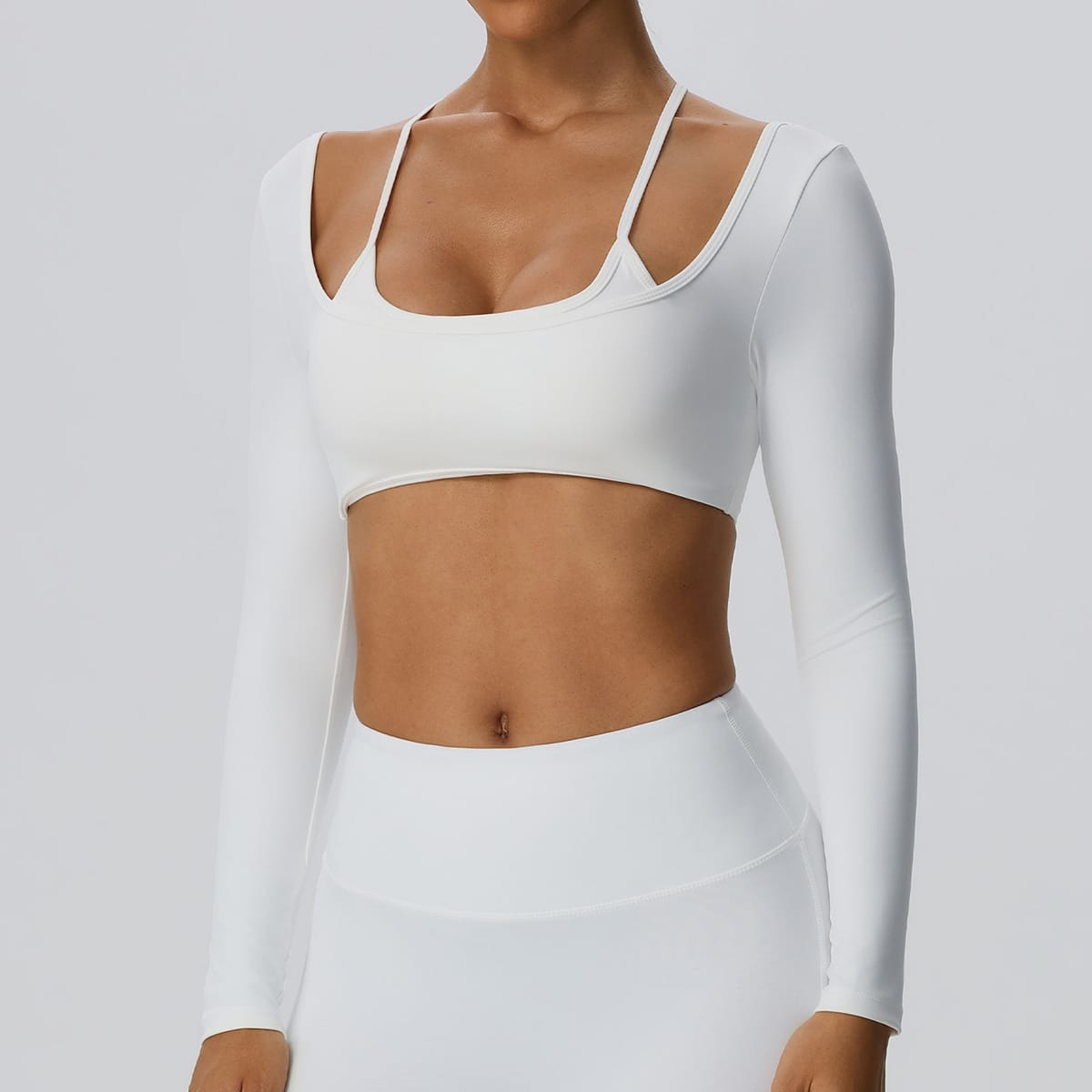 Front view of a white layered long sleeve cutout workout crop top.