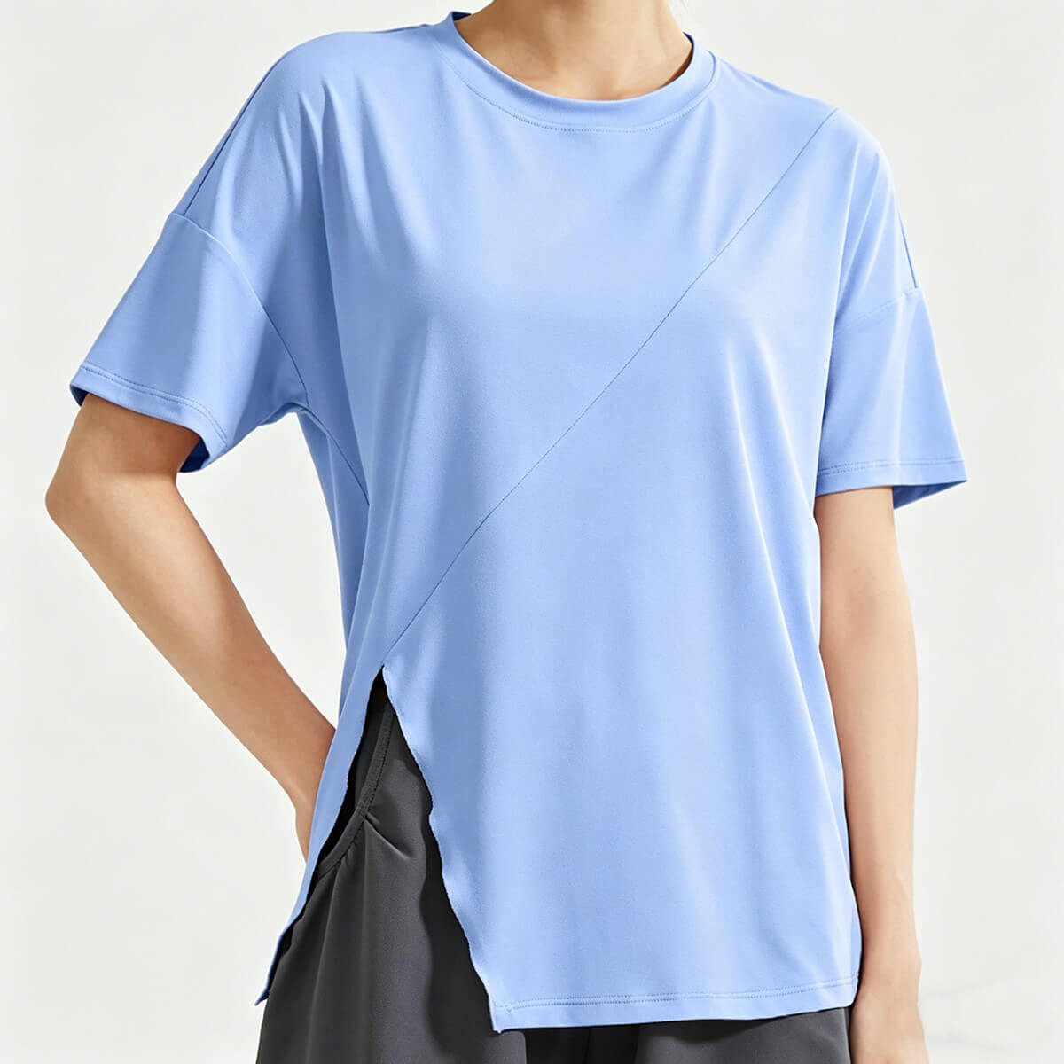 A women's light blue loose-fit workout shirt featuring a stylish side slit hem and breathable fabric, perfect for yoga and gym training.