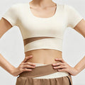 Front view of a women's cream short sleeve workout crop top featuring a stylish mesh cutout detail and flattering scoop neck for yoga and gym