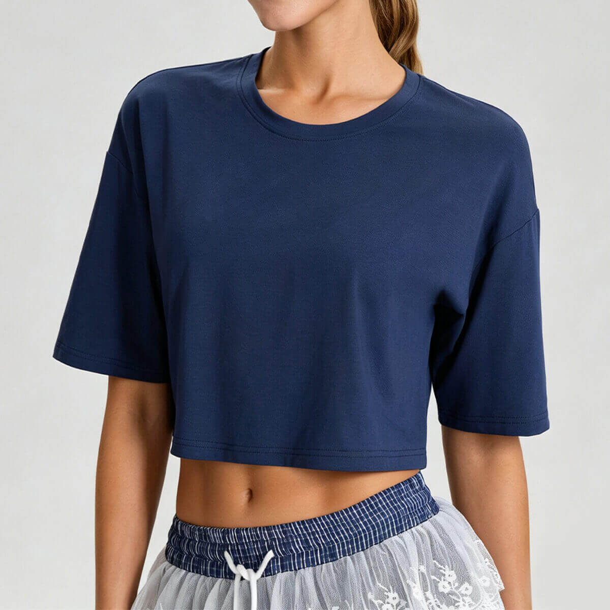 A woman posing in a navy oversized athletic crop top, highlighting the flattering cropped length.