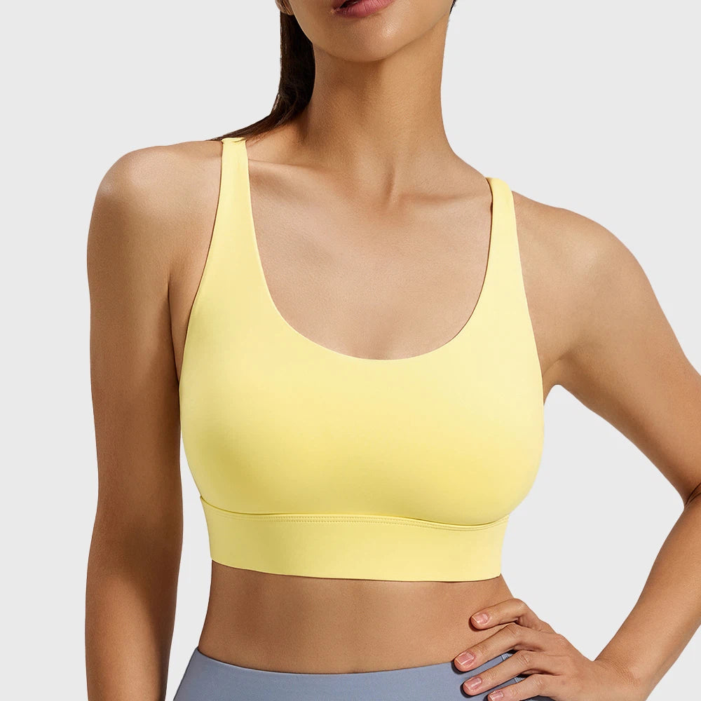 Lemon yellow padded fitness bra with mesh back design and custom logo placement, crafted by professional clothing manufacturer.