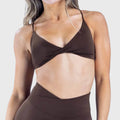 Front look of dark brown plunge twist yoga sports bra with custom logo, supplied by activewear manufacturer.