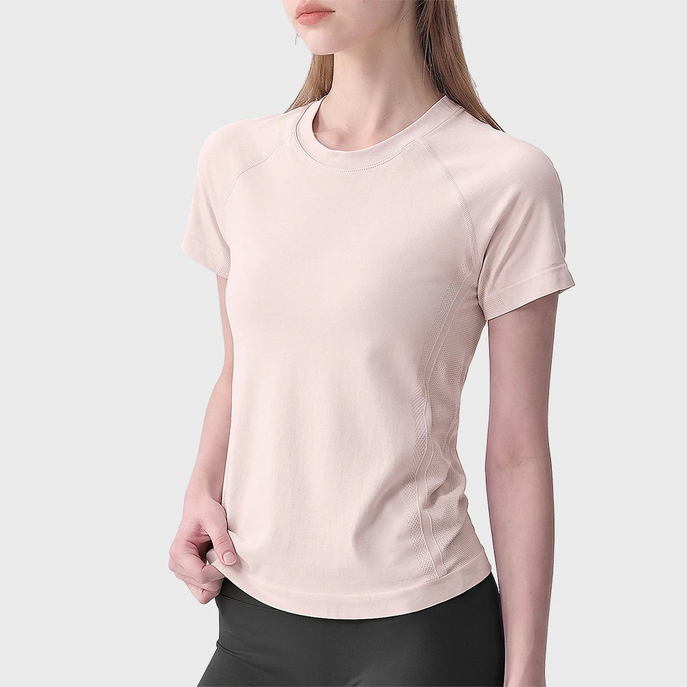 Light pink women's seamless athletic top with custom logo branding options from private label activewear manufacturer.