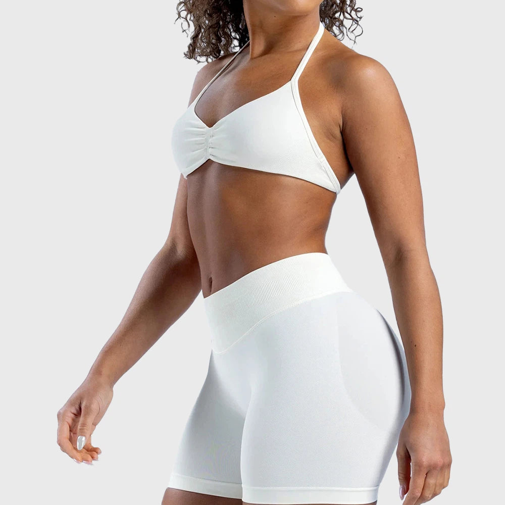 Side profile of women's seamless halter athletic running bra in white with custom logo, fitness apparel manufacturer.