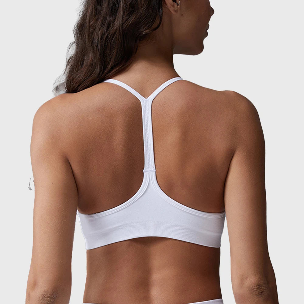 Back view showing skinny Y-back racerback strap design on women's white sports bra with custom logo, OEM gym wear manufacturer.