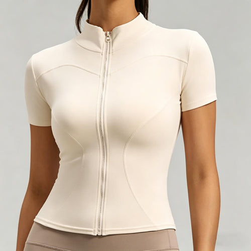 Women's slim fit short sleeve workout top in cream featuring a full zipper and contouring seams for a sculpted look.