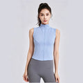 Women's slim fit sleeveless workout top in light blue featuring a full zip and stand collar for gym and yoga