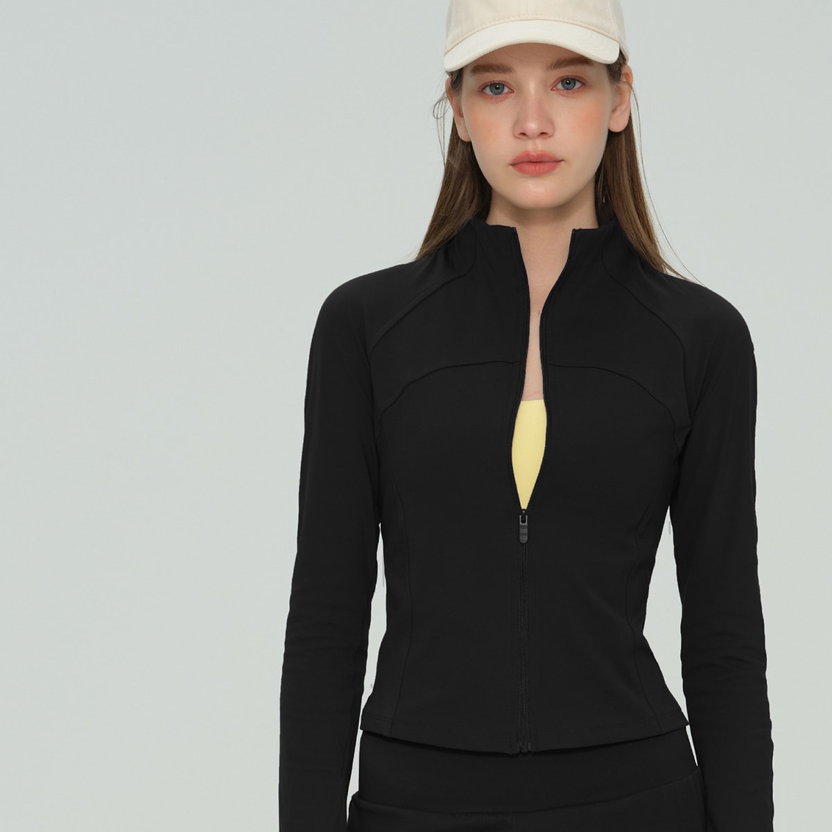 Woman wearing a classic black full-zip athletic training jacket.