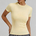 Front view of a pale yellow slim fit workout top for women featuring waist-shaping curved seams for a lean silhouette.