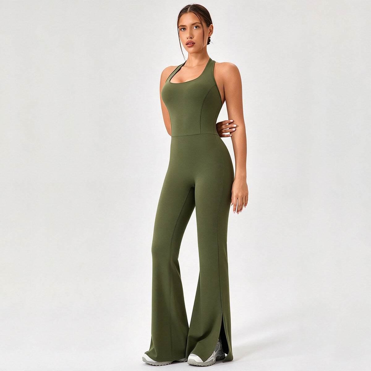 Model wearing an olive green backless flare-leg workout jumpsuit.
