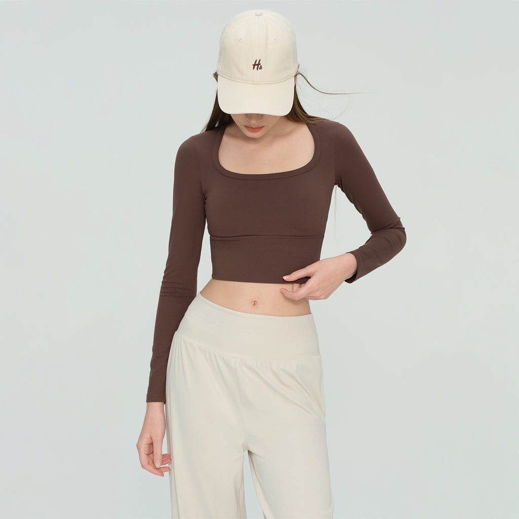 Model wearing a chocolate brown square neck long-sleeve workout crop top.