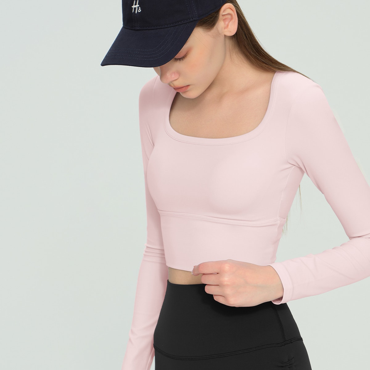 Front view of a pastel pink fitted long-sleeve workout crop top.