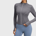 Women's stand collar reflective running jacket with thumbholes in slate grey with custom logo, OEM activewear manufacturer - front view.