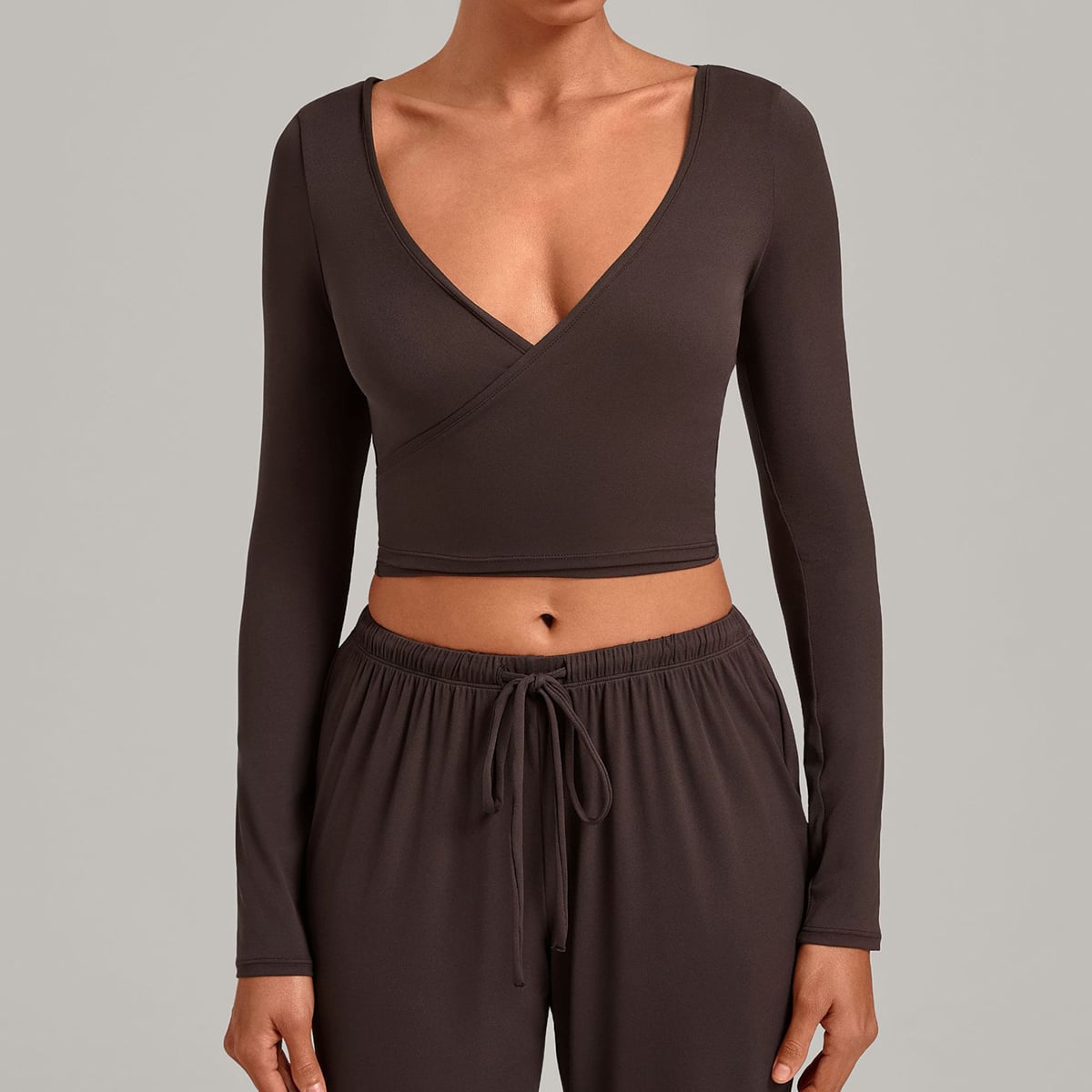 Model wearing a dark coffee long-sleeve crossover wrap top.
