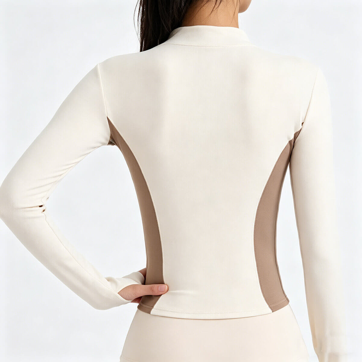 Back view of a women's breathable track jacket in beige and brown, highlighting the contoured seams and athletic silhouette.