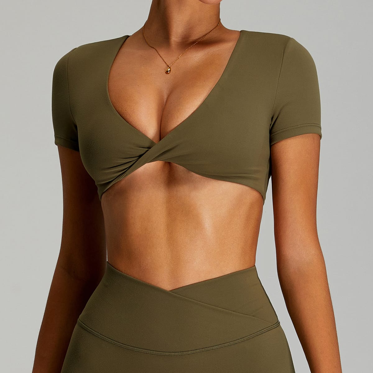 Front view of an olive green V-neck short-sleeve yoga crop top.