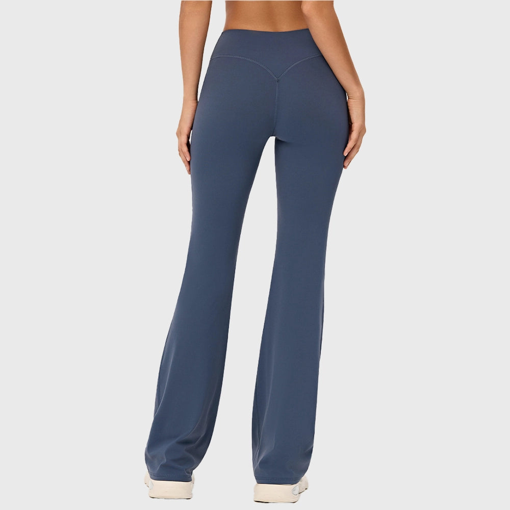 Back view showing V-shaped contour waistband and booty lifting seams on women's steel blue flare yoga pants with custom logo, OEM activewear manufacturer.